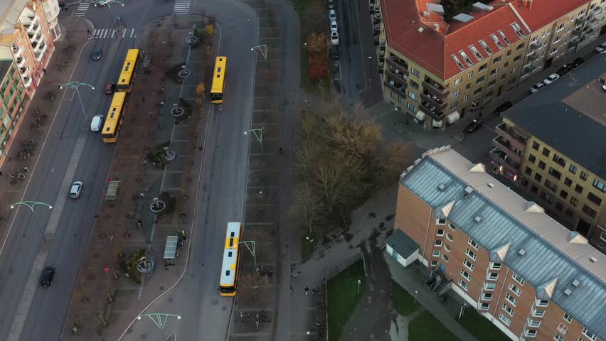 Aerial view of buildings with red roofs, roads, parked cars, and green spaces, creating a vibrant urban landscape, Malmo, Scania County, Sweden.