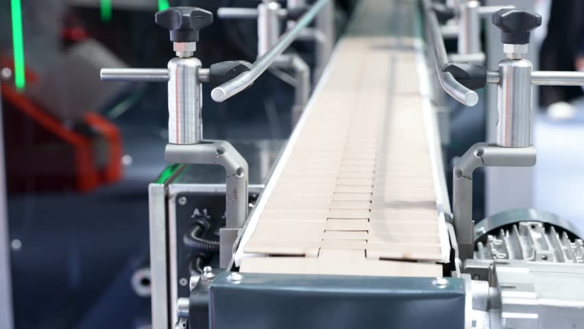 Empty conveyor belt system in a modern factory setting, representing halted production, supply chain disruption and industrial slowdown due to global economic challenges