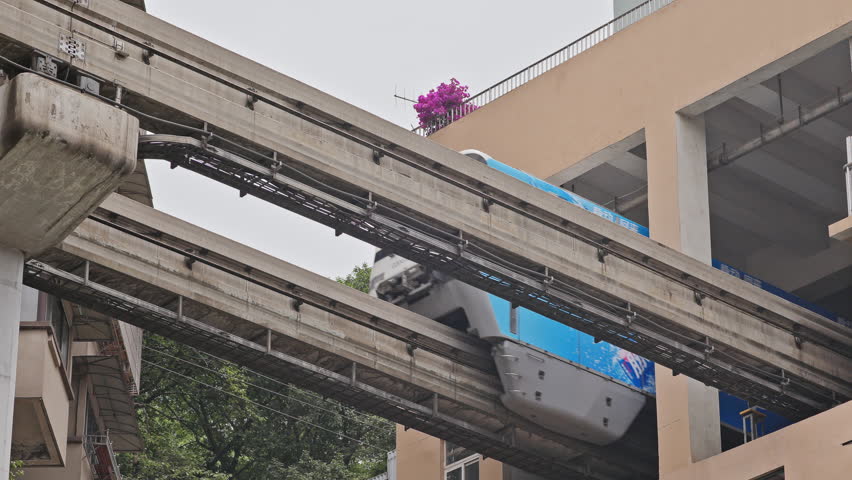 CHONGQING, CHINA - 28 MAY 2025 : train enters liziba station inside a building on bridge in Chongqing china