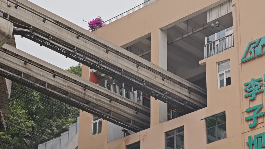 CHONGQING, CHINA - 28 MAY 2025 : train enters liziba station inside a building on bridge in Chongqing china