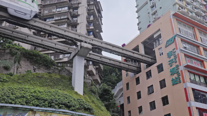 CHONGQING, CHINA - 28 MAY 2025 : train enters liziba station inside a building on bridge in Chongqing china