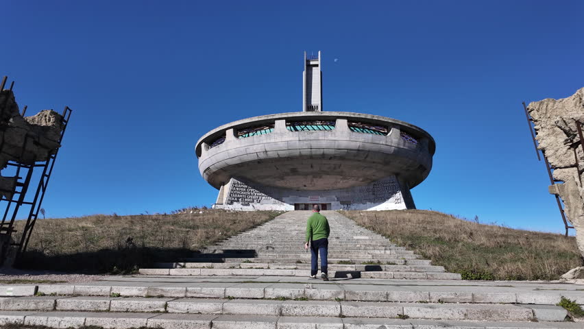 Tourist walking up the stairs to the Buzludzha monument in Bulgaria, a decaying communist era monument