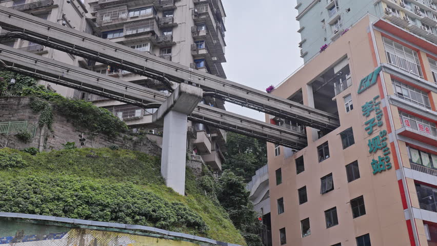 CHONGQING, CHINA - 28 MAY 2025 : train enters liziba station inside a building on bridge in Chongqing china