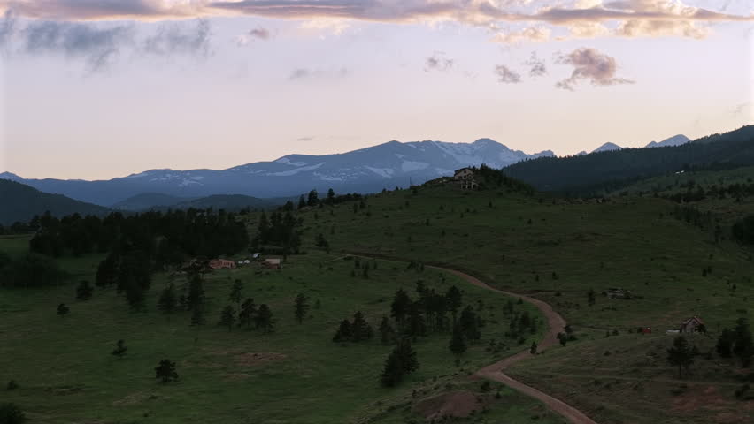 Drone footage of a summer sunset over the mountains near Boulder, Colorado. Aerial view of scenic wilderness, ridges, and forested landscapes.