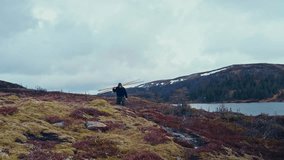 Man With Oars Walking Near The Lake In Åfjord, Norway - Wide Shot - Powered by Shutterstock - Get 15% off with code: PIKWIZARD15