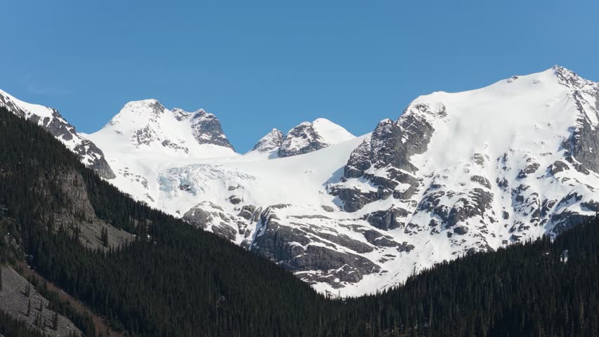 Majestic Snow-Capped Mountains With Glacier And Pine Forest Under Clear Blue Sky In British Columbia, Canada