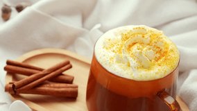 Adding cinnamon sticks Pumpkin spiced latte morning warming coffee. Fall Drinks for Halloween Thanksgiving Holiday beverage Autumn spicy cinnamon flavor seasonal hot drinking in cozy orange cup - Powered by Shutterstock - Get 15% off with code: PIKWIZARD15