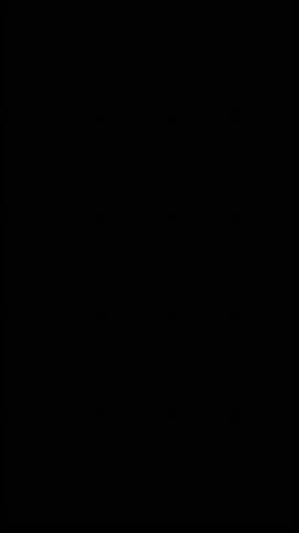 Close-up of meat cubes and chopped onions being cooked in a large outdoor pot on grass, with steam rising and a perforated spatula adding ingredients. Cooking process captured with dynamic panning