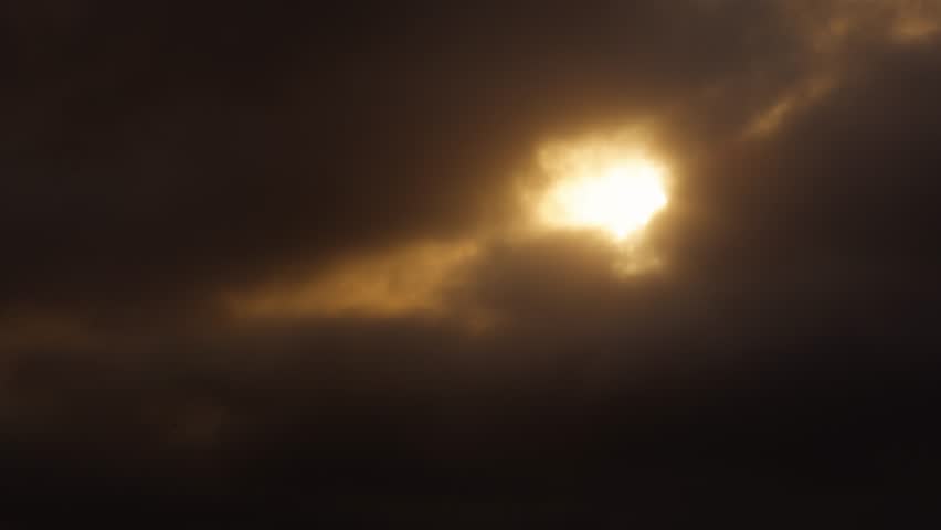 Thick golden clouds obscure the setting sun as it breaks through the sky over Taichung, bathing the air in warm twilight tones