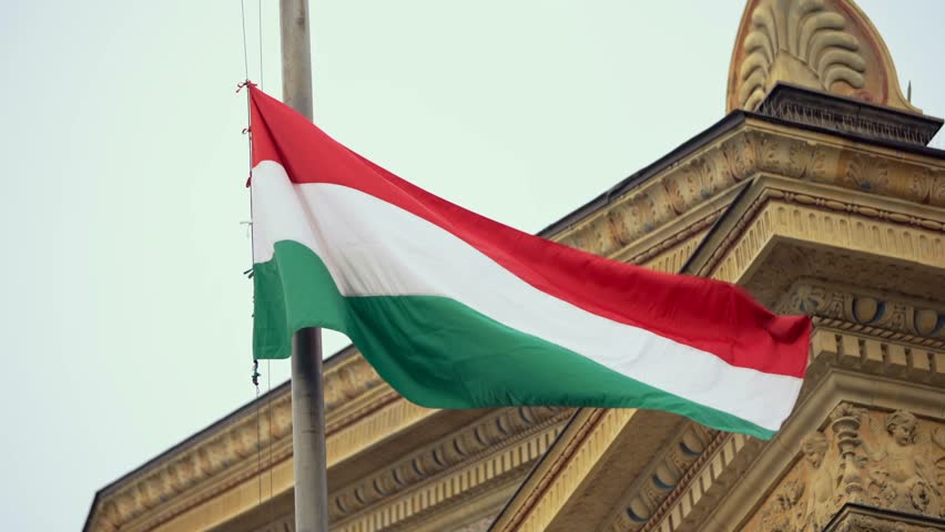 Slow motion of Hungarian flag gently fluttering near a historic building in Budapest, embodying the nation