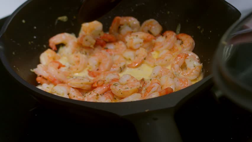 MACRO fried SHRIMP, housewife cooking shrimp stew seafood in a frying pan. Beautiful fried shrimp