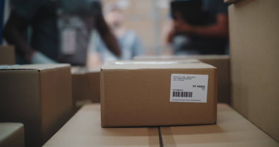 Multiethnic Workers Unloading Cardboard Boxes with Online Orders, E-Commerce Goods from Delivery Truck. Manager Using Tablet Computer and Barcode Scanner. Outside of Logistics Distribution Warehouse.
