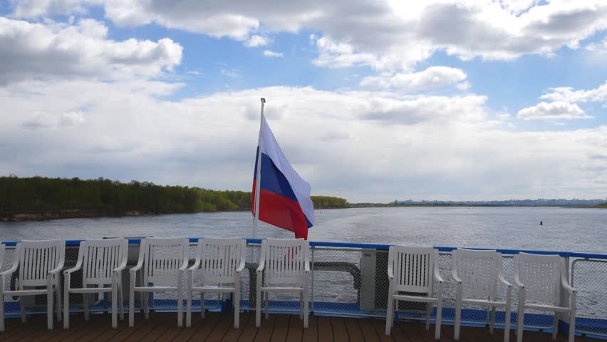 The Russian flag is flying at the stern of the passenger ship. Journey along the Volga River
