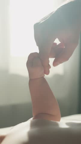 Three month old baby boy playing with father's hand and finger close up. Tender family morning in warm sunlights. Happy Parenthood. Unconditional Love of Dad and Child