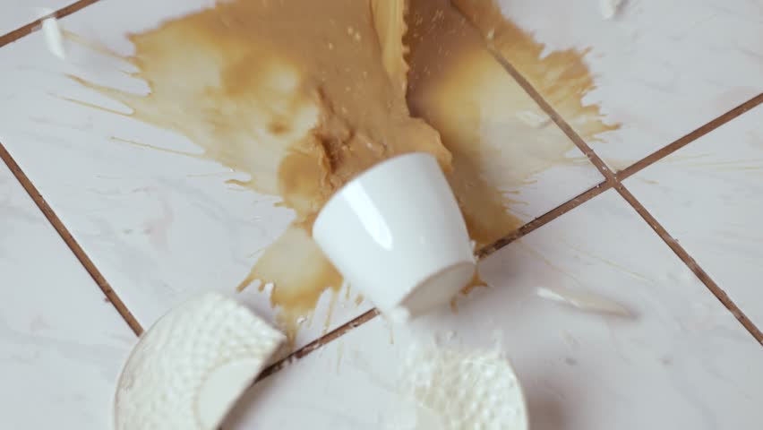 Dropping cup of coffee breaking on the kitchen tile floor, clumsy morning accident, slow motion 240 FPS footage