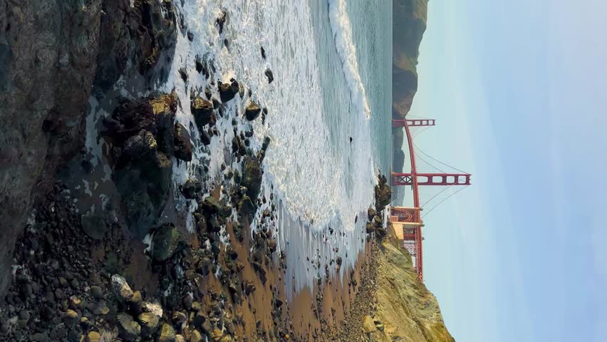 Sunset view on Golden gate bridge from Baker beach. Bay area. San Francisco landmark, travel destination, Vertical footage