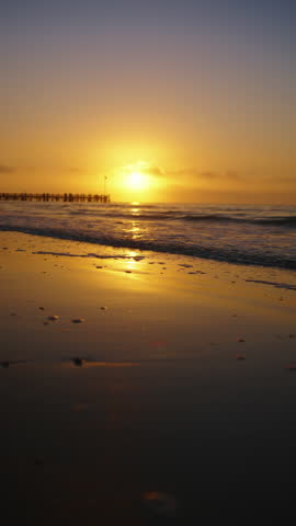 Vertical Screen: A breathtaking and stunning sunset over the calm and tranquil ocean at Key West, Florida, beautifully highlights vibrant colors reflecting on the waters glassy, smooth surface