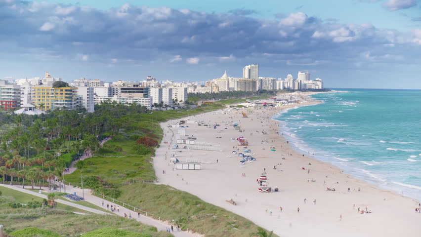 Pointe Pier in Miami Beach offers stunning views of golden sandy beaches, turquoise waters, and vibrant beachgoers, all framed by impressive, towering buildings that enrich the urban landscape