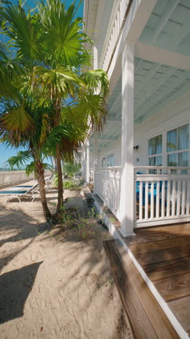Vertical Screen: Discover the serene and tranquil beauty of Key West, which features stunning beach views, swaying palm trees, and cozy porches perfect for the ultimate relaxation experience