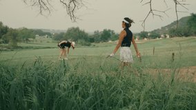 Two lady golfers on the tee box preparing to start their round. One places her tee in the ground while her female partner walks up. Outdoor golf course scene on a sunny day in slow motion - Powered by Shutterstock - Get 15% off with code: PIKWIZARD15