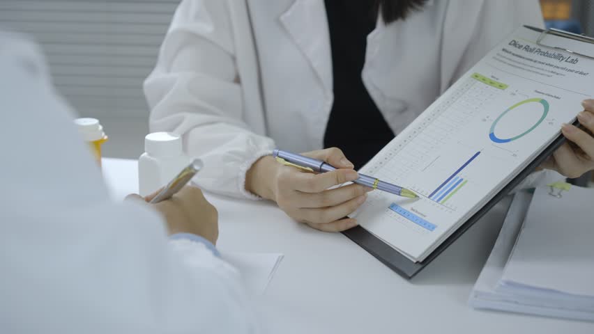 Medical research team collaborating, analyzing scientific data, discussing pharmaceutical research findings on laboratory workstation