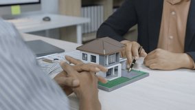 Professional architect presenting detailed architectural scale model of residential property to client during real estate meeting in modern office environment - Powered by Shutterstock - Get 15% off with code: PIKWIZARD15