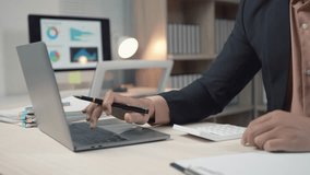 Professional businessman analyzing financial data on laptop, using calculator while working at desk in modern corporate office environment - Powered by Shutterstock - Get 15% off with code: PIKWIZARD15