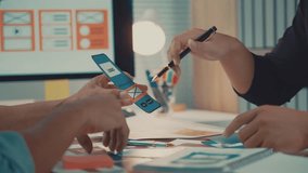 Professional web designers collaborating on mobile app prototype, developing user interface and wireframing innovative digital design solution in modern startup workspace - Powered by Shutterstock - Get 15% off with code: PIKWIZARD15