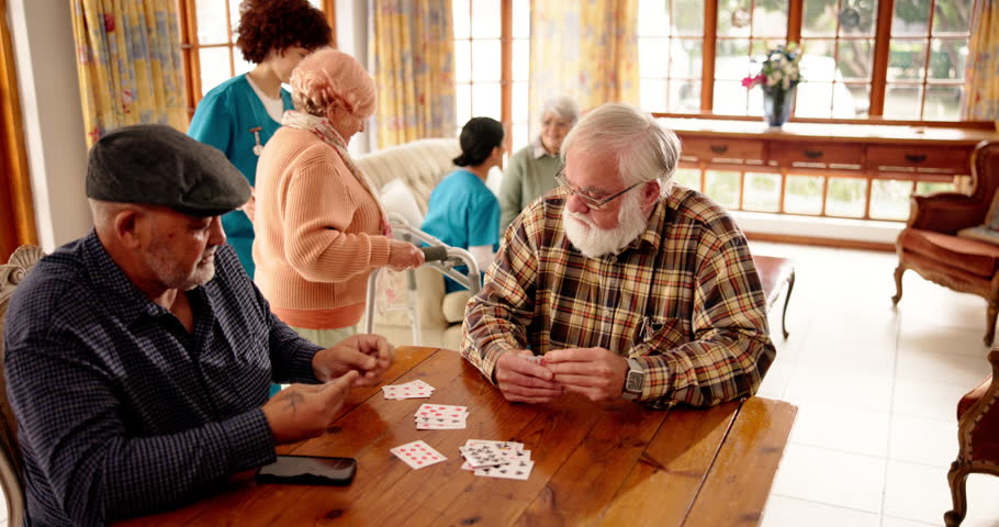 Senior men, friends or playing cards in retirement, talk or contest with deal, challenge or bet. Elderly people, together or relax with game, competition or conversation in retirement home for bridge