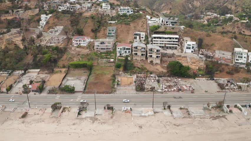 Wide aerial dolly shot of cleared lots along Pacific Coast Highway at Las Flores Canyon after the wildfire in Malibu, California. 4K