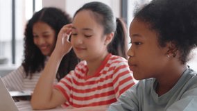 Smiling Three Diverse little girls learning together on a laptop in a classroom, showing joy, Multiethnic children with E-learning and online classroom in a relaxed educational. - Powered by Shutterstock - Get 15% off with code: PIKWIZARD15