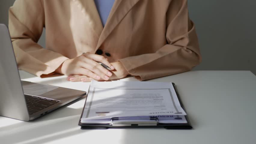 Young businesswoman holds a resume and evaluates it. Views the personal history of job applicants. Recruitment concept.