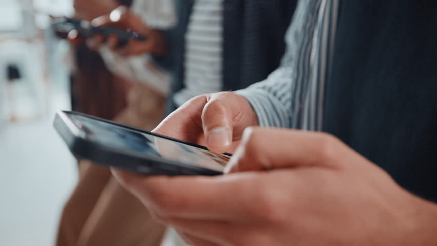 People, hands and typing with phone in waiting room for career research or job search at office. Closeup, candidates or person browsing with mobile smartphone in row or line for online application