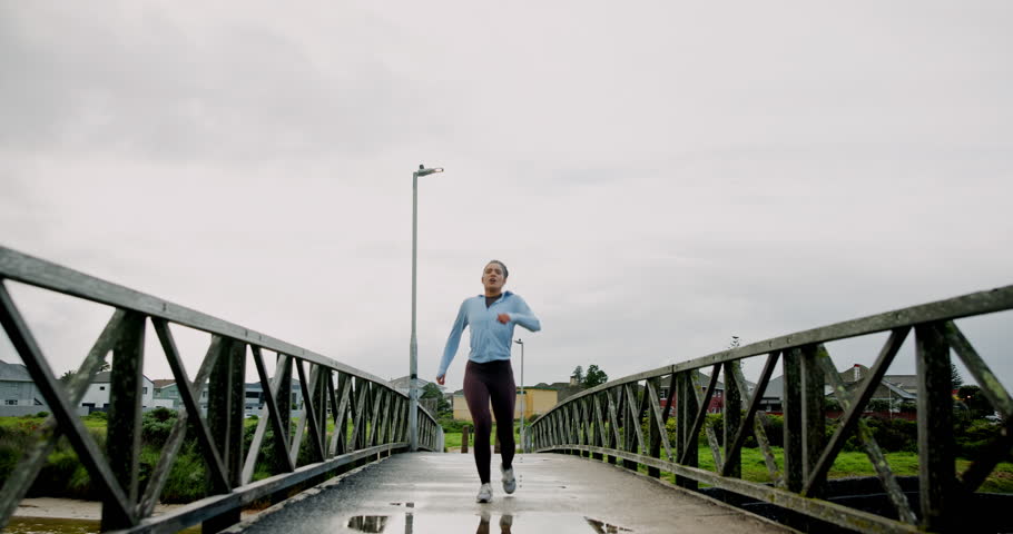 Runner, woman and tired with fitness on bridge for marathon burnout, breathing and exercise break. Winter cardio, athlete and exhausted in nature for race training, running challenge and overworked