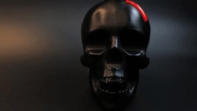 A black human skull in close-up view, with vivid red liquid slowly dripping over its surface. The contrast between the dark matte skull and the glossy red fluid creates a dramatic and intense visual. - Powered by Shutterstock - Get 15% off with code: PIKWIZARD15
