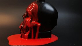 A black human skull in close-up view, with vivid red liquid slowly dripping over its surface. The contrast between the dark matte skull and the glossy red fluid creates a dramatic and intense visual. - Powered by Shutterstock - Get 15% off with code: PIKWIZARD15