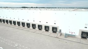 Aerial view of logistics warehouse exterior with loading platforms. Truck bays at distribution center with closed loading gates. Commercial infrastructure for freight operations - Powered by Shutterstock - Get 15% off with code: PIKWIZARD15