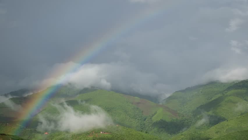Rainbow over the greenery rainforest mountains and hills