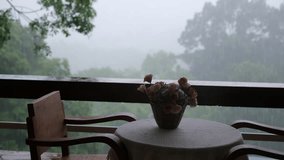 Flower pot and wooden table on balcony while it's raining - Powered by Shutterstock - Get 15% off with code: PIKWIZARD15