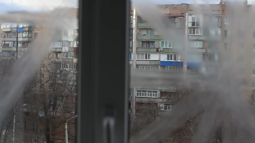 In Kramatorsk, Ukraine, a window taped for protection offers a grim view of civilian life. This scene underscores the constant threat and urban impact of the ongoing Ukraine-Russia war.