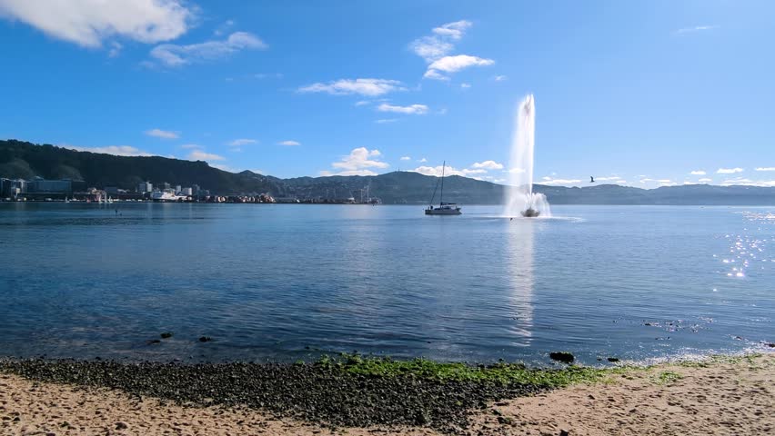 Yacht on Wellington harbour with water fountain at Oriental Parade in capital city Wellington, New Zealand Aotearoa