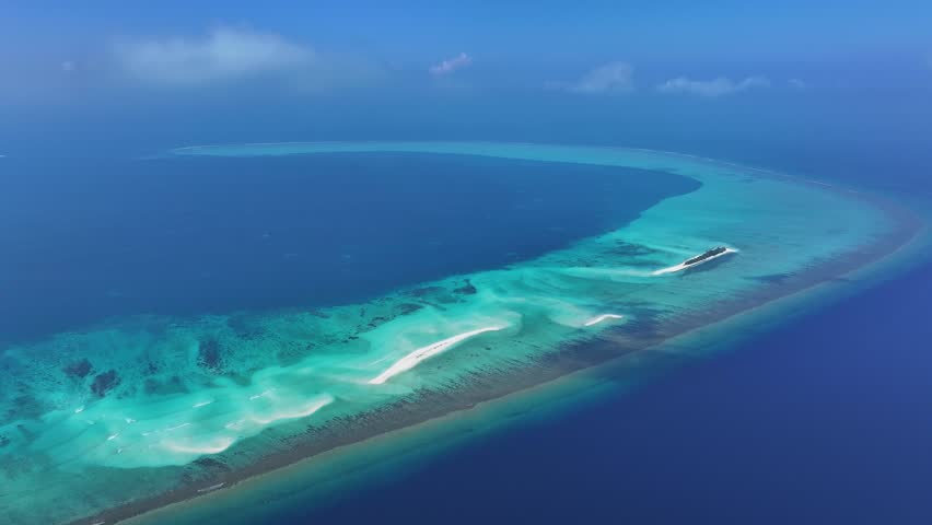 Aerial view of the pristine Fulhadhoo island sandbank, a ribbon of white sand and turquoise waters contrasting against the deep blue sea, Fulhadhoo, Alif Dhaal Atoll, Maldives.
