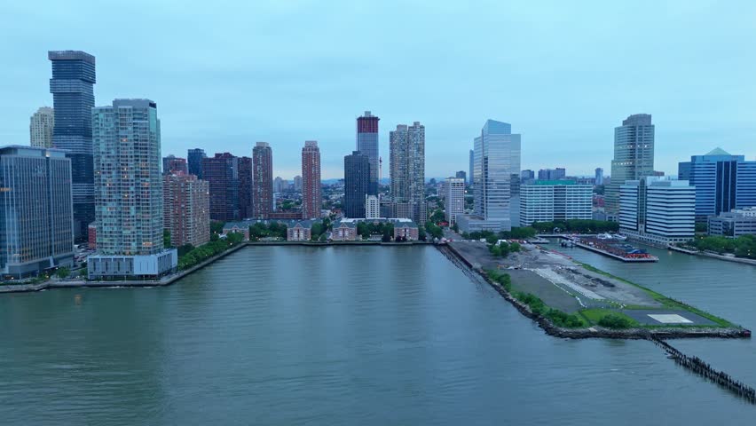 Jersey City skyline along Hudson River, modern high-rise buildings and waterfront on cloudy, overcast day, New Jersey, USA