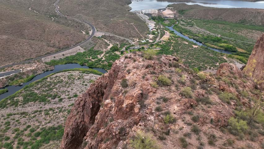 Aerial view of the Salt River winding through the landscape, showcasing the contrast between the dark water and the arid terrain, Mesa, Arizona, United States.