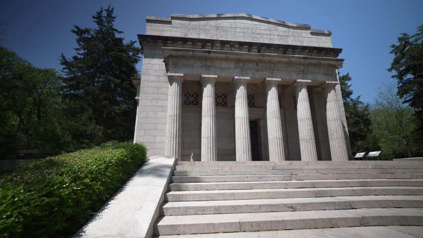 Visitors explore the grand memorial dedicated to Abraham Lincoln, located at his birthplace in Hodgenville, Kentucky, surrounded by lush greenery and historic significance.