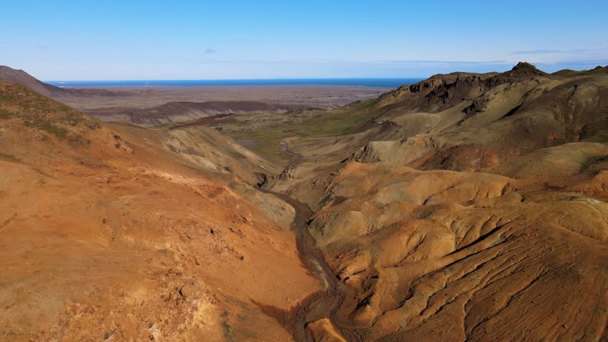 Aerial view of Trolladyngja reveals a rugged landscape with contrasting earth tones and textures under a clear sky, Grindavik, Grindavíkurbaer, Iceland.