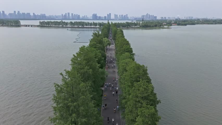 4k aerial drone footage of people on bridge that divides a lake into two