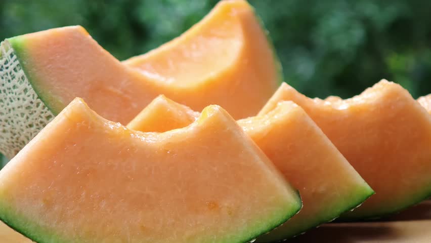 Cantaloupe melon slices on wooden