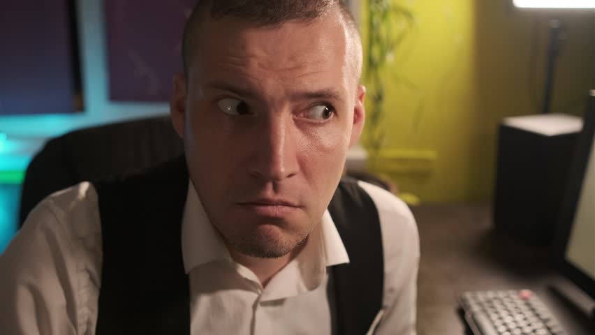 A man in formal attire sits at a desk in a dark office displaying a tense expression as he looks toward an unseen source of disturbance The atmosphere is charged with anticipation - Powered by Shutterstock - Get 15% off with code: PIKWIZARD15