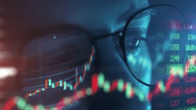 Trader wearing glasses is working on laptop computer. Screen with stock market charts and Bitcoin BTC or Ethereum ETH data analysis reflection. Broker trading online. Altcoins crypto currency trading - Powered by Shutterstock - Get 15% off with code: PIKWIZARD15
